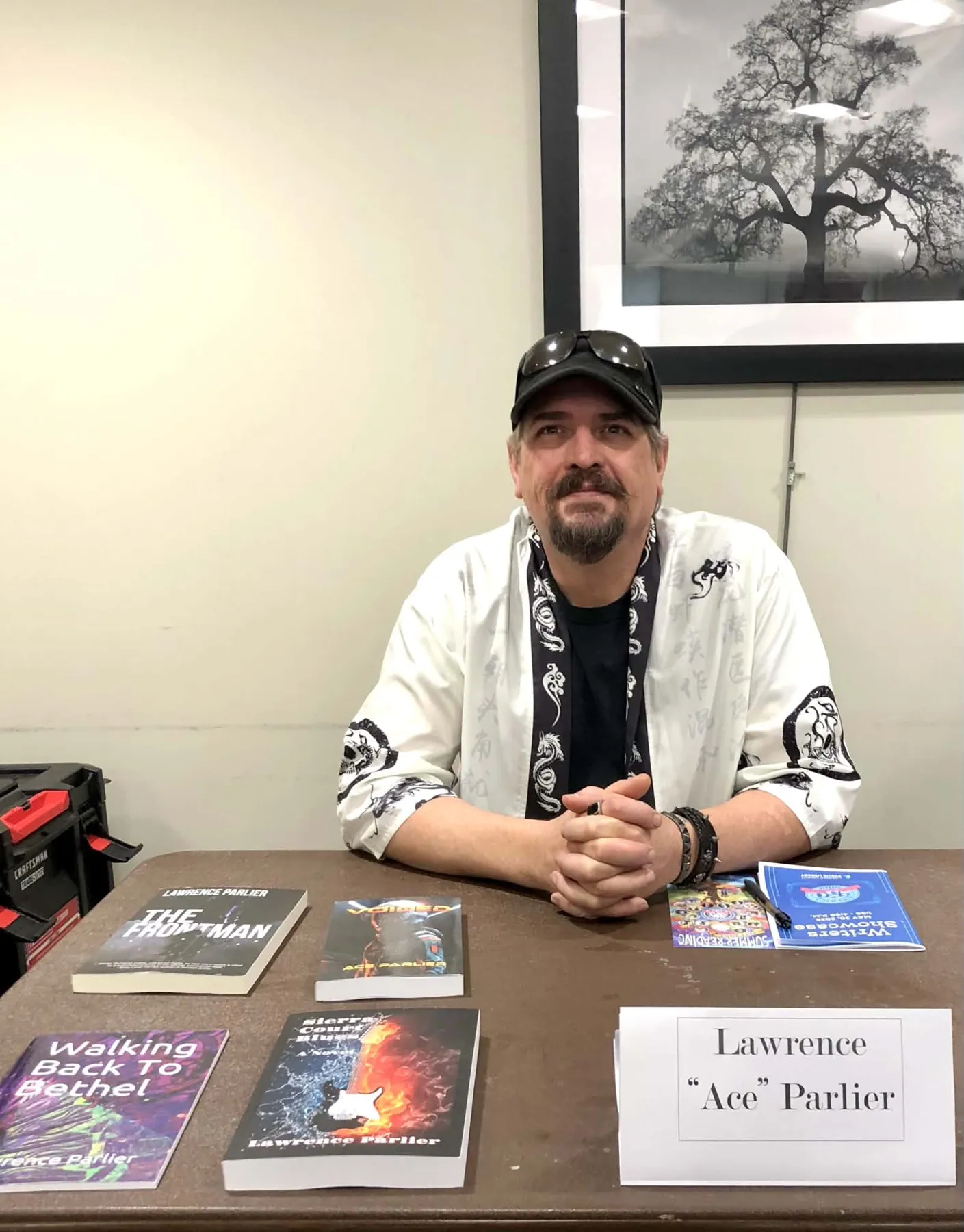 Ace Parlier at a book signing table with his novels and poetry chapbook