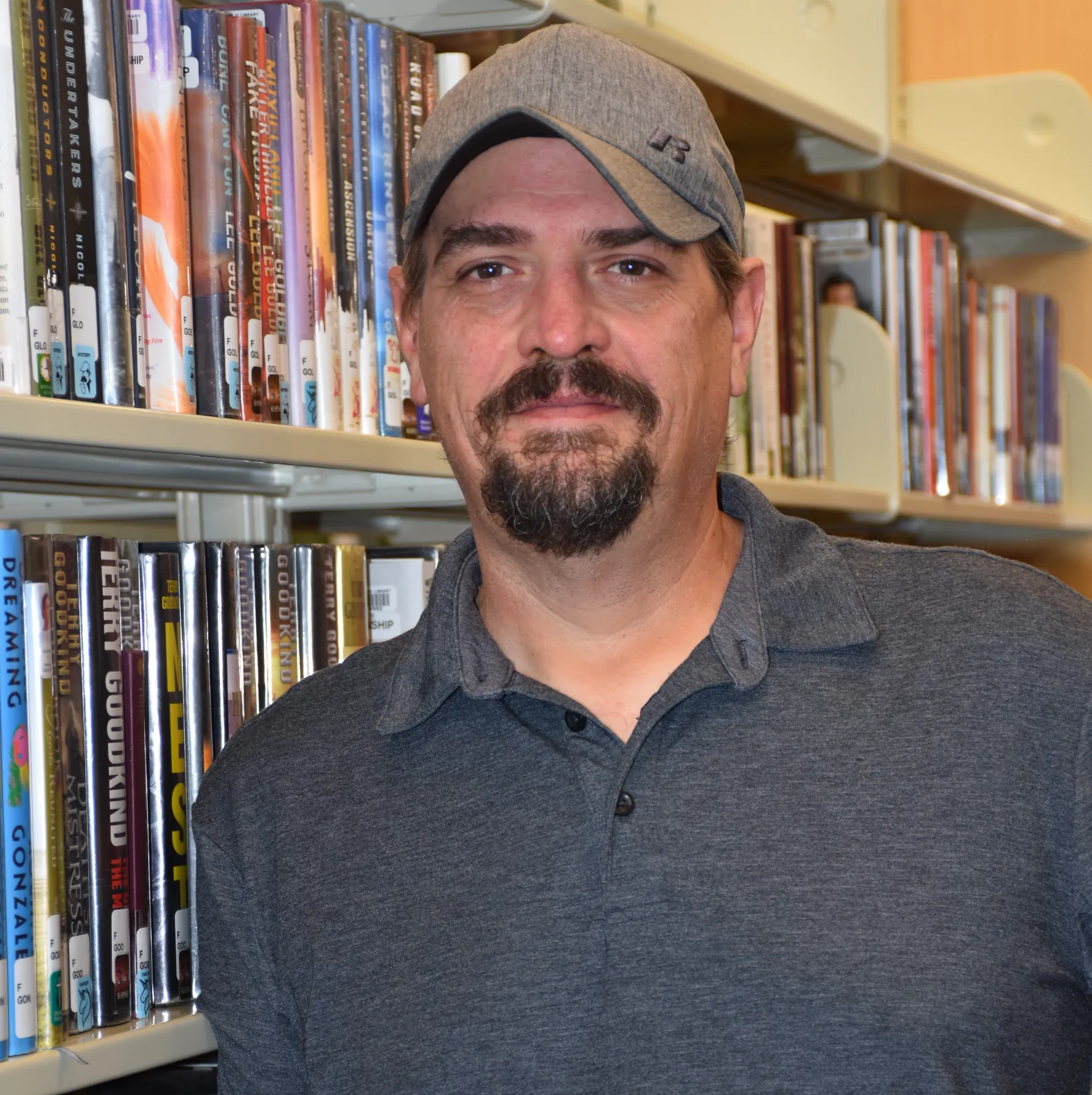 Lawrence Parlier standing in front of library shelves